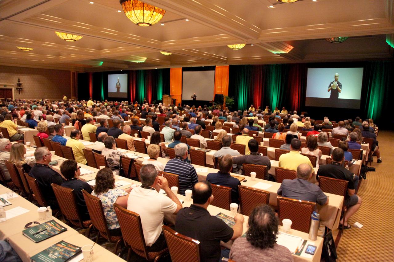 Large corporate event audience with magician on stage